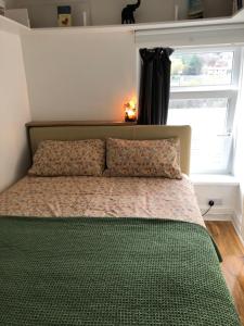 にあるThe Pathfinder's Retreat - 1 bedroom houseのベッドルームに枕2つと窓が備わります。