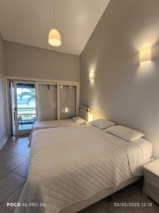 une chambre avec deux lits et une vue sur l'océan dans l'établissement Condo frente mar, à Barra do Una