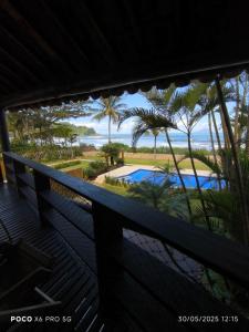 une vue depuis le balcon d'un complexe hôtelier avec piscine dans l'établissement Condo frente mar, à Barra do Una