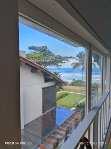 d'une fenêtre offrant une vue sur l'océan. dans l'établissement Condo frente mar, à Barra do Una