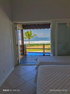 une chambre avec deux lits et une vue sur l'océan dans l'établissement Condo frente mar, à Barra do Una
