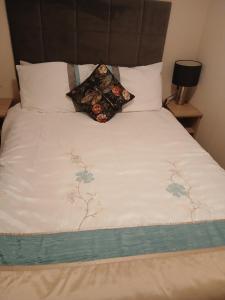 - un lit avec une couette blanche et 2 oreillers dans l'établissement Warm and Cosy, Torbay Waterside Holiday Home, à Paignton