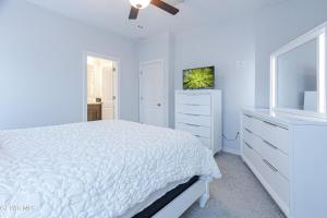 Dormitorio blanco con cama blanca y vestidor en Comfortable 2, en Canutillo