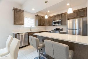 Una cocina con gabinetes de madera y electrodomésticos de acero inoxidable. en Comfortable 2, en Canutillo