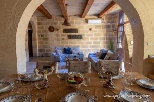 een eetkamer met een tafel met glazen erop bij Tal Lilly Xaghra in Xagħra