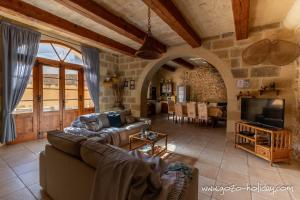 een woonkamer met een bank en een tv bij Tal Lilly Xaghra in Xagħra