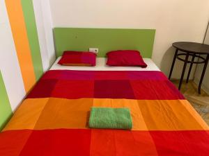 a bed with a colorful blanket on top of it at Pest Downtown Inn in Budapest