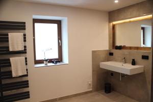 a bathroom with a sink and a window at Ferienapartment Horn in Sebnitz