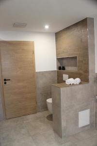 a bathroom with a toilet and a wooden door at Ferienapartment Horn in Sebnitz