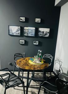 a dining room table with two bottles and chairs at Apartament W Starym Obiektywie in Kowary