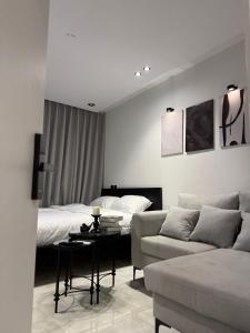 a living room with a couch and a bed at Luxury studio with smart self check-in أستديو راقي بدخْول ذاتي حي الصحافة in Riyadh