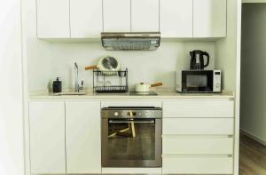 eine Küche mit Herd und Mikrowelle in der Unterkunft RentUp - Moderno y Luminoso Studio Premium con Amenities en el corazon de Buenavista in Estación San Isidro