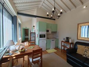 a living room with a table and a kitchen at A Arribana in Nordestinho