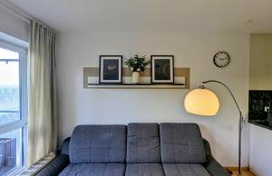 - un salon avec un canapé et une horloge murale dans l'établissement Weltenbummler Lodge in Schwarzenberg, à Schwarzenberg/Erzgebirge