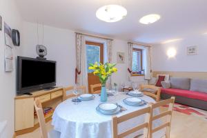 a living room with a table and a tv at Alpine Retreat Gaja Kranjska Gora - Happy Rentals in Kranjska Gora