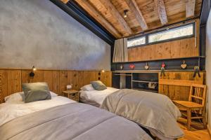 two beds in a room with wooden walls at La Ferme à Roland ski in - ski out - Happy Rentals in Chamonix-Mont-Blanc +24 photos