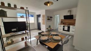 un salon avec une table, des chaises et une télévision dans l'établissement CasaFranken, à Wiesenthau