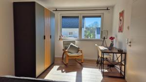 une pièce avec un bureau, une chaise et une table avec un ordinateur portable dans l'établissement CasaFranken, à Wiesenthau