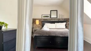 a bedroom with a bed with a brick wall at KingstonStays Spacious Historic Downtown Stableman's House Loft in Kingston