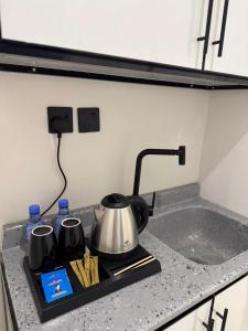 a stove top with a tea kettle on a counter at Luxury studio with smart self check-in أستديو راقي بدخْول ذاتي حي الصحافة in Riyadh +17 photos