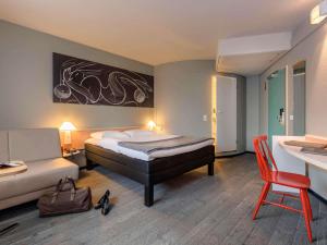 汉堡汉堡阿拉斯特瑞宜必思酒店的一间卧室，配有一张床、一张桌子和一把椅子