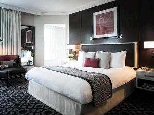 um quarto de hotel com uma cama grande e uma cadeira em Sofitel Lafayette Square Washington DC em Washington mais 172 fotografias