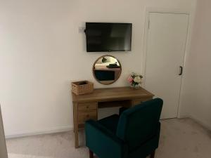 a room with a mirror and a chair and a table at 60 Springfield Road in Stornoway