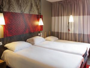 two beds sitting next to each other in a hotel room at ibis Paris La Defense Courbevoie in Courbevoie +88 photos