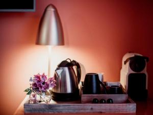 a table with a lamp and a vase with flowers at Hotel Mercure Roma Corso Trieste in Rome