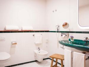 a white bathroom with a sink and a toilet at Hotel Mercure Roma Corso Trieste in Rome