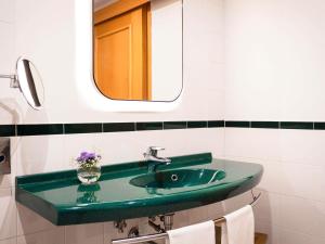 a bathroom with a green sink and a mirror at Hotel Mercure Roma Corso Trieste in Rome +109 photos