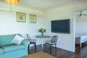 ein Wohnzimmer mit einer Couch und einem Tisch mit Stühlen in der Unterkunft Grasmere Farm in Gruyere