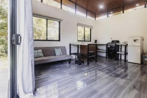 sala de estar de planta abierta con sofá y cocina en Newly built Surf Hideaway in Avellanas Beach, en Playa Avellana