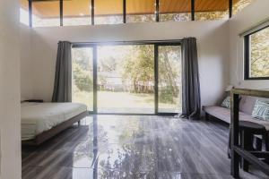 Un dormitorio con una cama y una ventana grande en Newly built Surf Hideaway in Avellanas Beach, en Playa Avellana