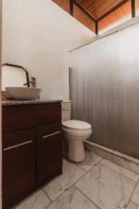 Un baño con un inodoro blanco y un lavabo. en Newly built Surf Hideaway in Avellanas Beach, en Playa Avellana