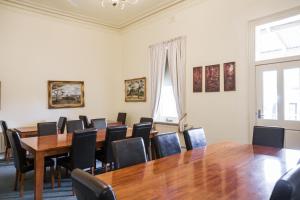 einen Konferenzraum mit einem Holztisch und Stühlen in der Unterkunft Lancefield Guest House in Lance Field