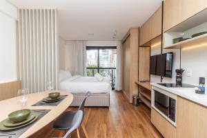 a hotel room with a bed and a table with chairs at Studios Sampa - Vila Buarque - Santa Casa in São Paulo