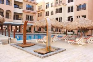 a resort with chairs and umbrellas and a swimming pool at Rosa Boho Hotel And Aqua Park in Hurghada