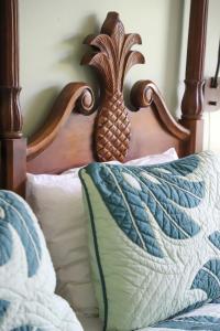 uma cama com cabeceira de madeira com um abacaxi. em The Cliffs at Princeville by ResorTime em Princeville