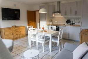 Una cocina y una sala de estar con mesa y sillas. en Aurora Lodge, en Frielendorf