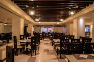 a dining room with tables and chairs and lights at Rosa Boho Hotel And Aqua Park in Hurghada