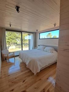 Maravillosa Casa en Puertecillo的一间带大床和大窗户的卧室