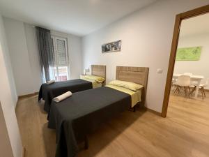 two beds in a room with a table and chairs at SF40 Vut in Lugo