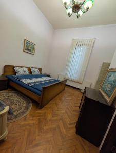 ein Schlafzimmer mit einem Bett und einem Holzboden in der Unterkunft Cazare central Craiova in Craiova