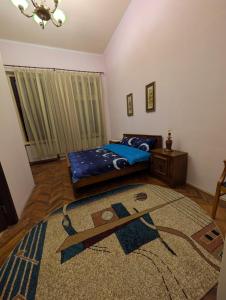 ein Schlafzimmer mit einem Bett und einem Teppich auf dem Boden in der Unterkunft Cazare central Craiova in Craiova