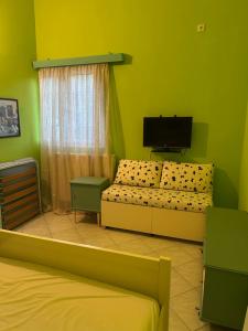 ein Zimmer mit zwei Betten und einem Flachbildfernseher in der Unterkunft Elena's Guest House in Aiándion