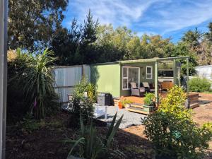 a green tiny house in a garden at Fantail at Bluestone Retreat in Leeston