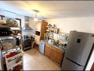 Una cocina con refrigerador de acero inoxidable y gabinetes de madera. en Gemütliche 2-Zimmer Wohnung in Boblingen, en Böblingen