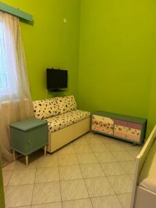 ein Wohnzimmer mit Sofa und Fernseher in der Unterkunft Elena's Guest House in Aiándion + 10 Fotos