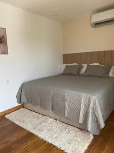 ein Schlafzimmer mit einem großen Bett mit einem Teppich in der Unterkunft Apartamento novo in Itaquatiara